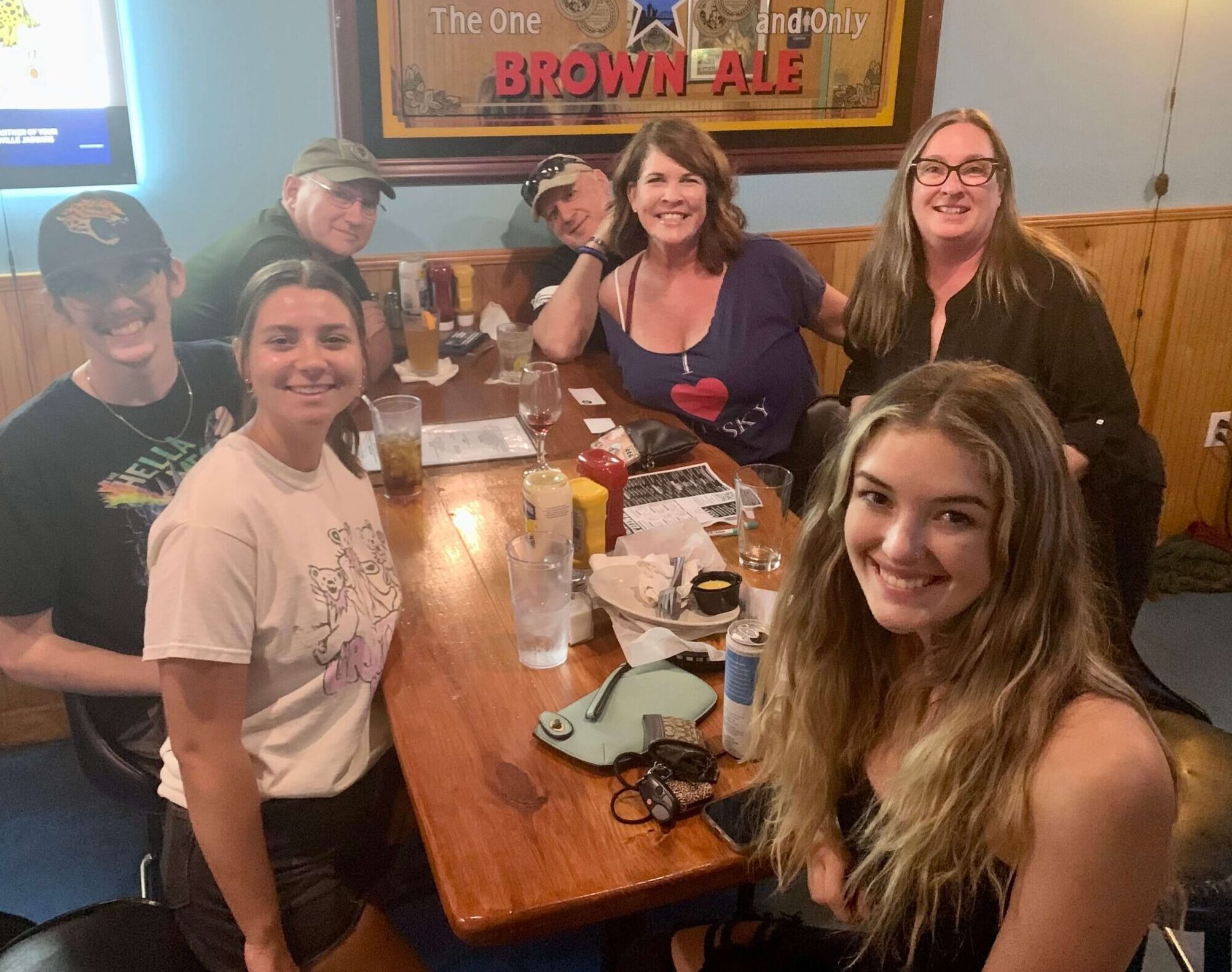 Monkey's Uncle Tavern Jacksonville Beach FL 32250 trivia night: group of young people and adults smiling with a Newcastle Brown Ale sign behind them