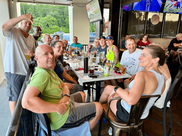 The Brass Tap Tampa FL 33618 trivia night: large group of adults seated outside on the patio smiling