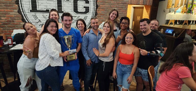 Legends Tavern & Grille Plantation, FL 33324: trivia night, group of adults smiling with a trophy in front of a brick wall with the bar's logo