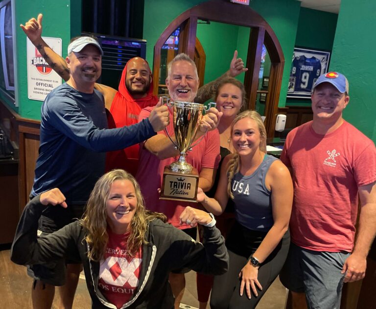 Duffy's Sports Grill Sarasota FL 34243 trivia night group of middle aged people smiling and making strong arm gestures